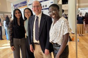 graduating fourth years in BME pose in front of a poster with Dr. Allen