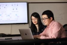 Professor Jundong Li works with a student at a laptop