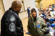 Leland Melvin speaks to a young community member at the screening of "The Space Race"