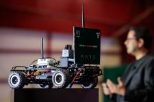 Behl shares how his career in autonomous racing began with co-founding the f1tenth small-scale autonomous racing platform, the car's relatively small size evident in the foreground..