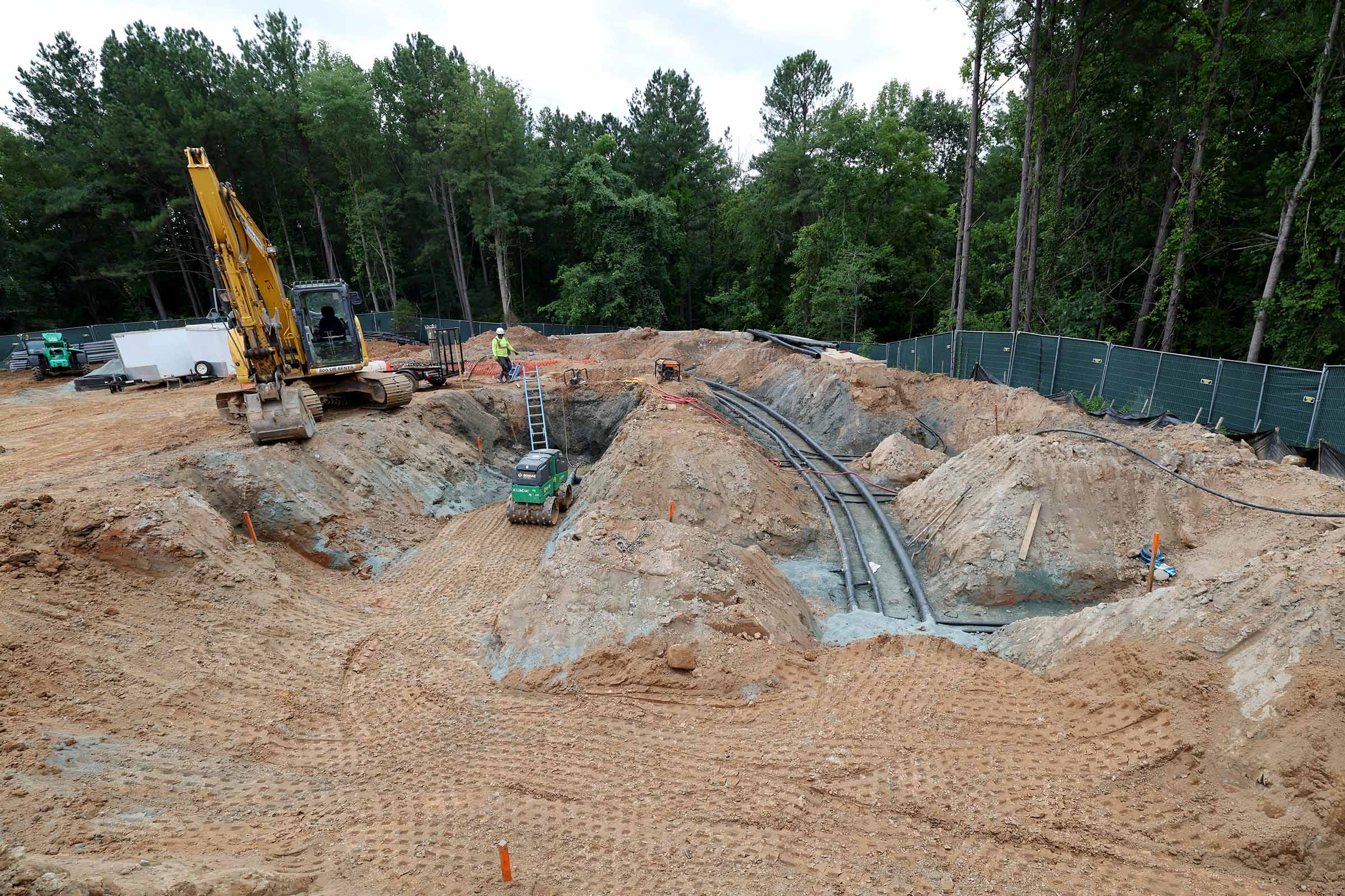 A construction site with earth-movers and pipes laid in the ground.