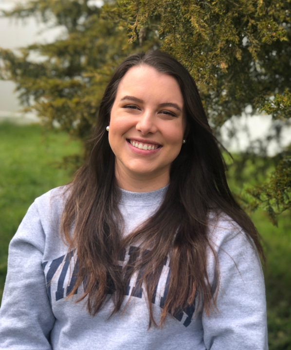 Portrait of a smiling young woman, Kristyn Ardrey, wearing a University of Virginia sweatshirt.