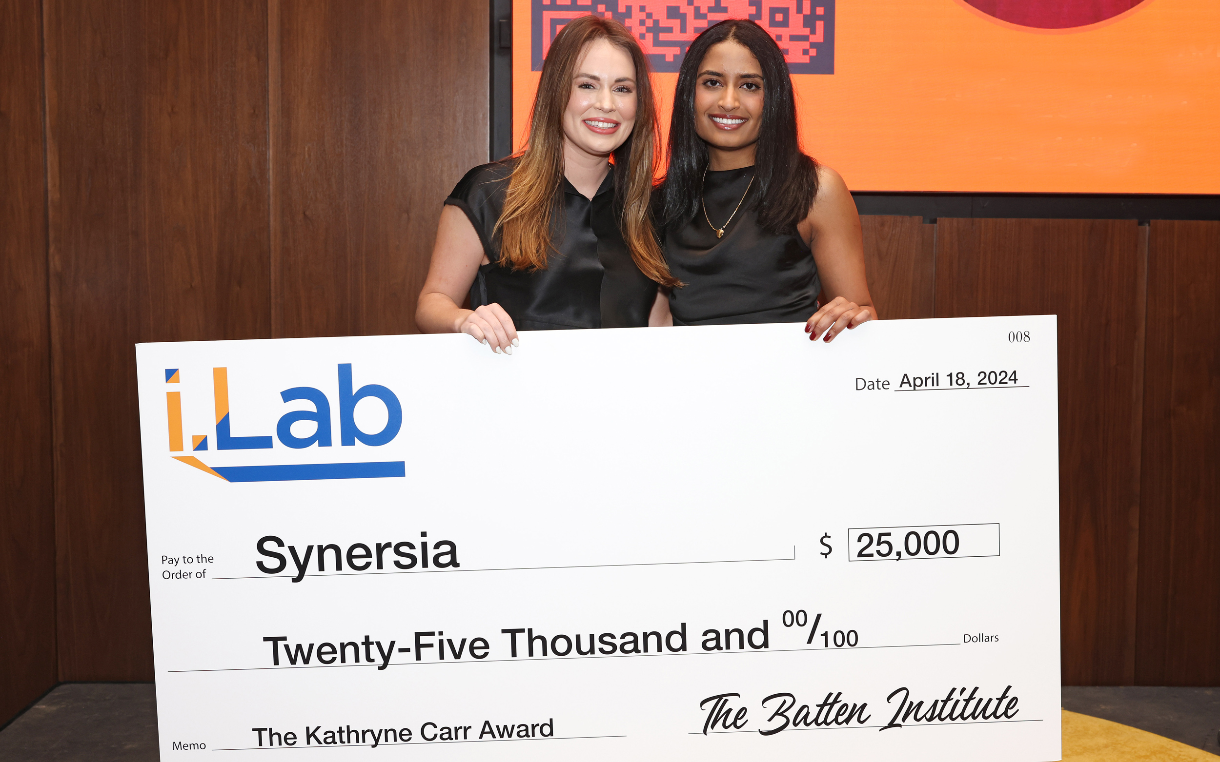 Two women holding a giant check