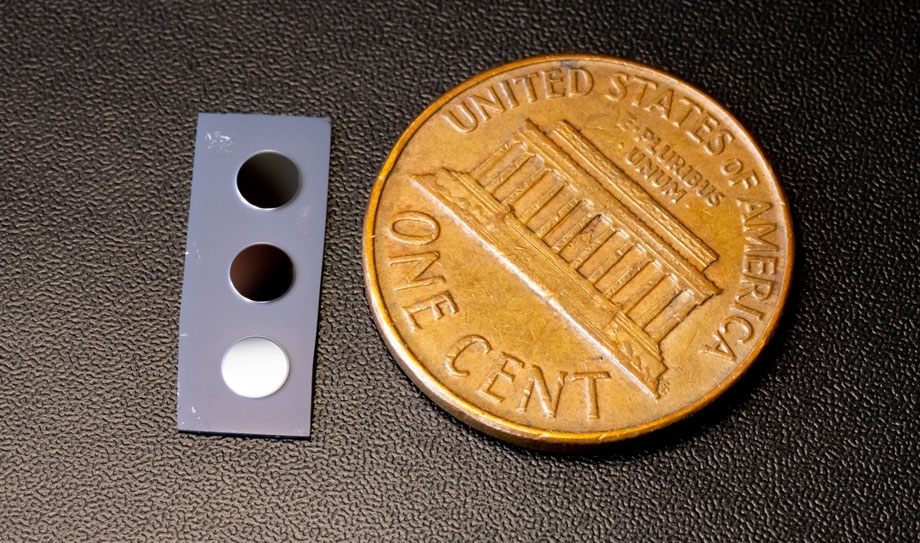 a small silicone chip next to a penny for scale