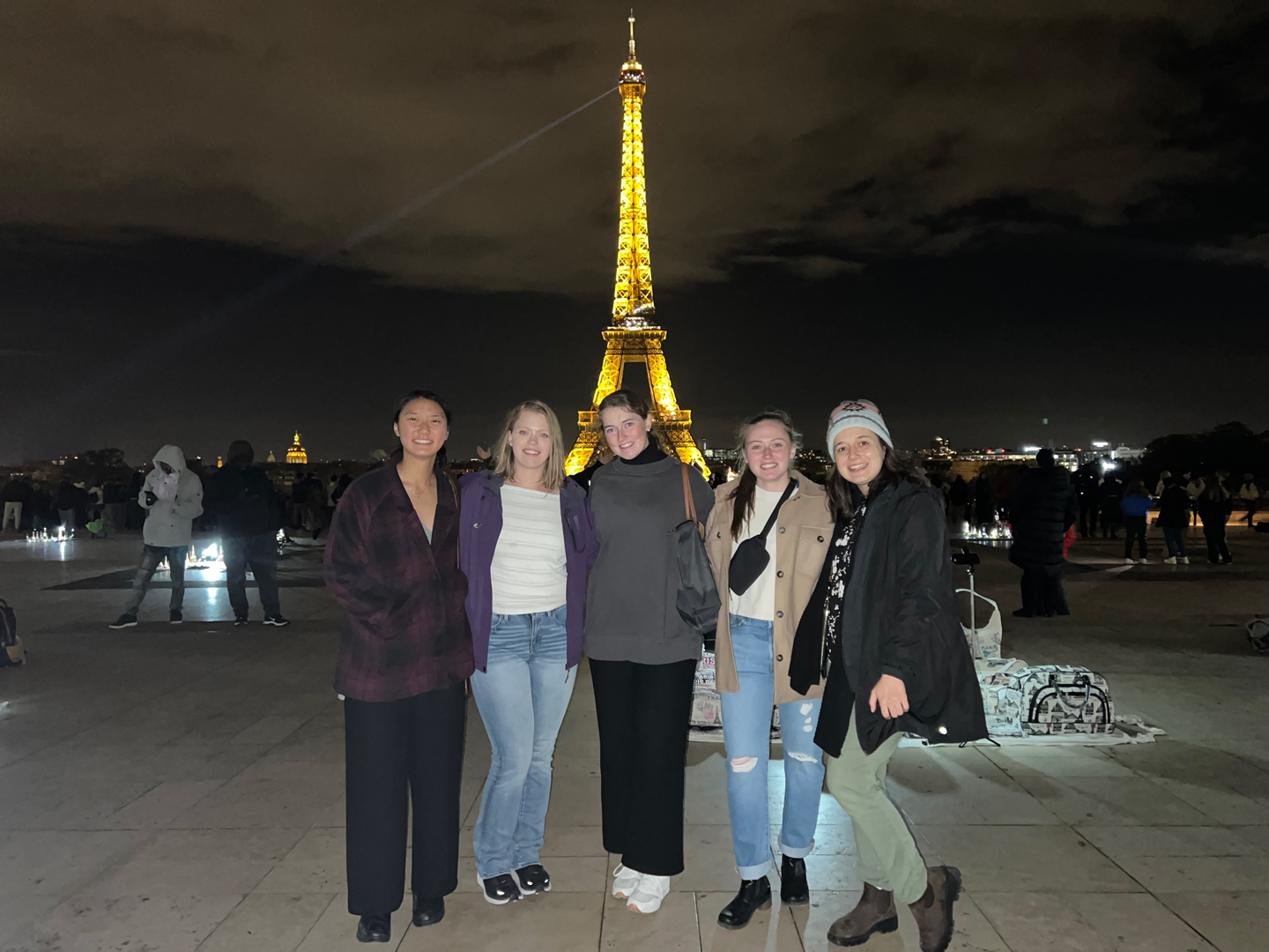 Five women posing in front of Paris' Eiffel Tower