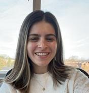 Image of Hannah smiling in front of a window