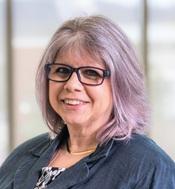 Image of woman wearing glasses smiling by window