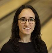 Woman in black sweater wearing glasses and smiling