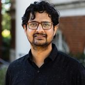 man wearing glasses and black shirt smiling