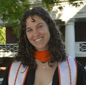 Image of woman smiling in regalia outside