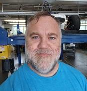 Image of man in blue shirt smiling in lab