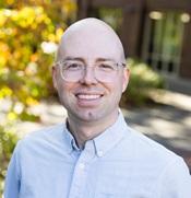 Image of man in light blue shirt with glasses smiling