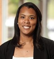 woman wearing black jacket and white shirt smiling outside