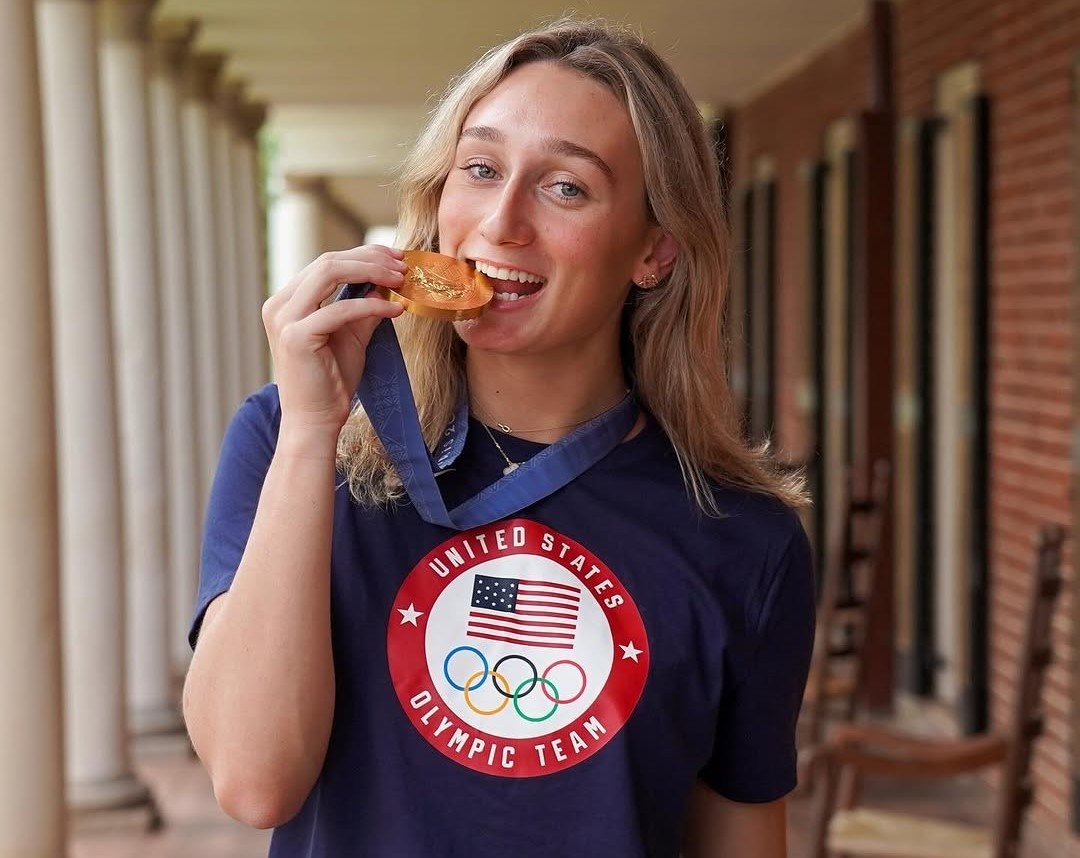 Emma Weber has fun demonstrating the solidness of her gold medal.