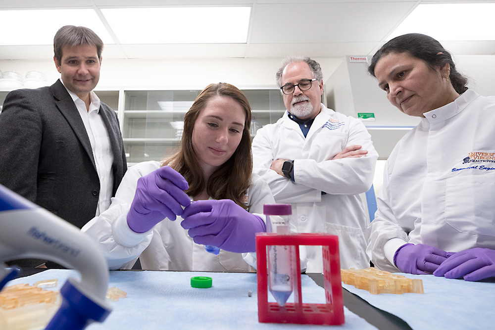 Associate professor Gavin Garner, left, professor George Christ, center, and lab manager Poonam Sharma, right, look on as Ph.D. student Rachel Bour prepares to seed a scaffold with cells. (Photo by Dan Addison, University Communications)