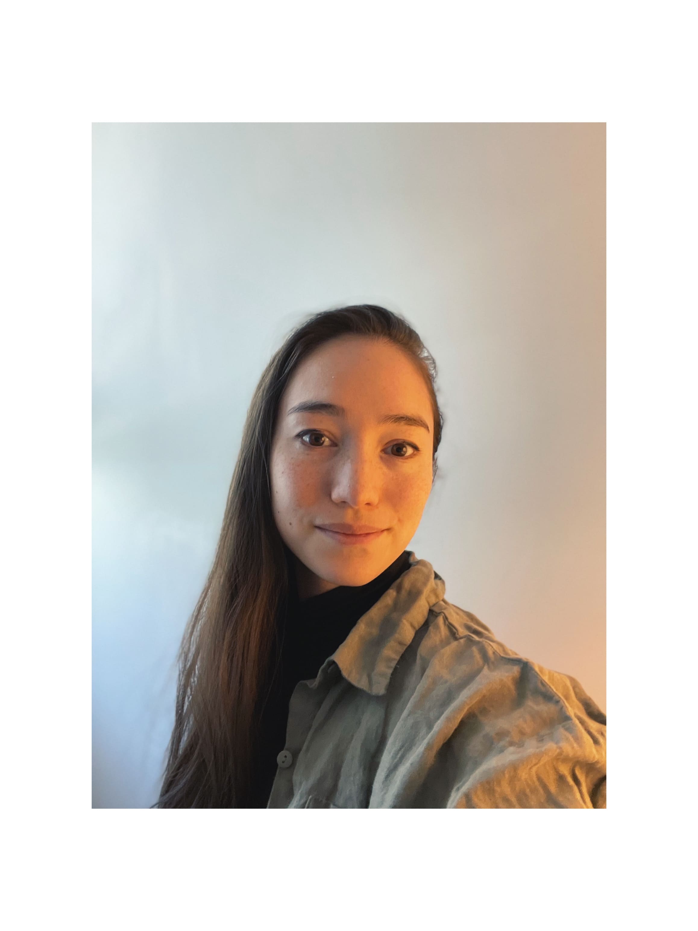 Woman standing in front of blank wall smiling