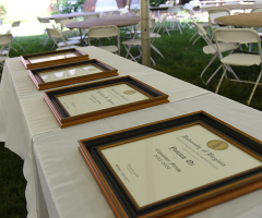 Certificates celebrating promotion and tenure arranged on top of a table with a white tablecloth