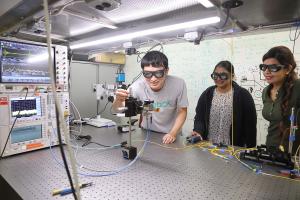 graduate students adjust equipment in the Bowers lab