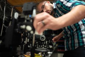 Student adjusts a piece of equipment in a lab