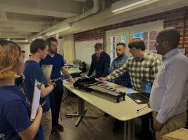 Students standing around a table with an electronic xylophone