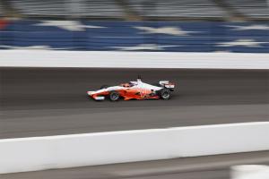 A blurred image of CAVCAR rounding a corner at Indianapolis Motor S