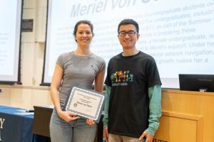 image of woman receiving an award certificate from a male professor