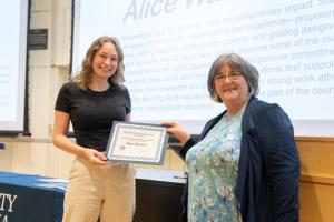image of woman man receiving an award certificate from a female professor