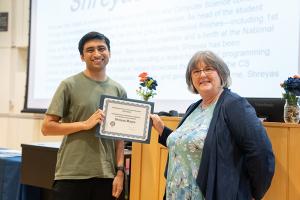 image of man receiving an award certificate from a female professor