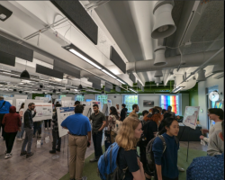 Image set inside UVA Link Lab of 2024 AI/ML Resource fair pictured are multiple people at posters talking.