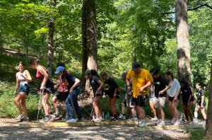 College students work together on a ropes course challenge