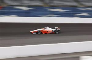 A blurred image of CAVCAR rounding a corner at Indianapolis Motor S