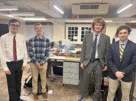 Four capstone student stand in front of their project. 