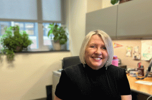 Photo of a woman at as desk in an office.