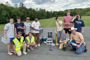 Students pose with their rocket engine