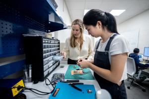 Prof. Amanda Watson examines equipment with a graduate student.