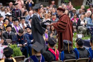 Chair Scott Acton presents a student with a diploma
