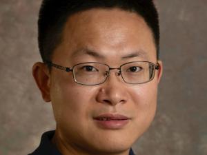 image of man wearing a dark collared shirt and glasses