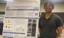 Caleb Tyson next to his research project poster