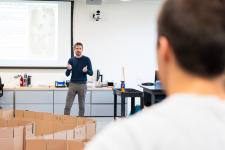 The professor explains the rules in front of the room.
