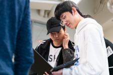 Students confer over code on a laptop