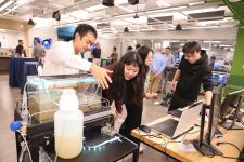Researchers demonstrate an interactive environmental engineering project involving sensors and a water tank during UVA Link Lab Research Day.