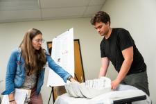 a student shows an element of their project to a faculty member