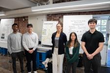 Students stand with a capstone poster