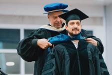 Graduate is hooded by advisor