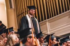 A student stands during the ceremony