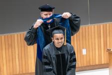 A Ph.D. graduate is hooded