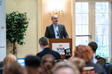 Speaker at a podium at Grad Thesis SLAM! event