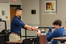 A student shows off a model during a capstone presentation