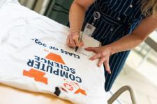Students sign t-shirts at the brunch