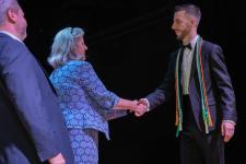 An award winner shakes Dean West's hand